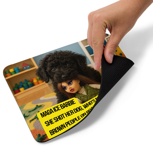 A hand lifts the bottom right edge of a standard mouse pad printed with the image of a black puppy in a toy room. He's on a tug surrounded by toy soldiers. He has a fashion doll in his mouth. She has long dark hair and perfect makeup. The text logo for leoshaiku.com is shown as is the political, satirical, anti-MAGA haiku that reads MAGA Ice Barbie
She Shot her dog, who's next?
Brown People on Boats
This view shows the thickness of the pad.