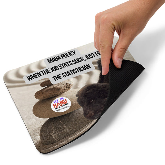 Standard Mouse Pad printed with a small black dog looking up into the camera from his place in a zen sand garden with a cairn of rocks. Political, satirical, anti-MAGA Haiku reads:
MAGA Policy
When the Job Stats Suck, Just Fire
The Statistician
The text logo for leoshaiku.com is displayed to the left of the dog.
This view shows the thickness of the pad