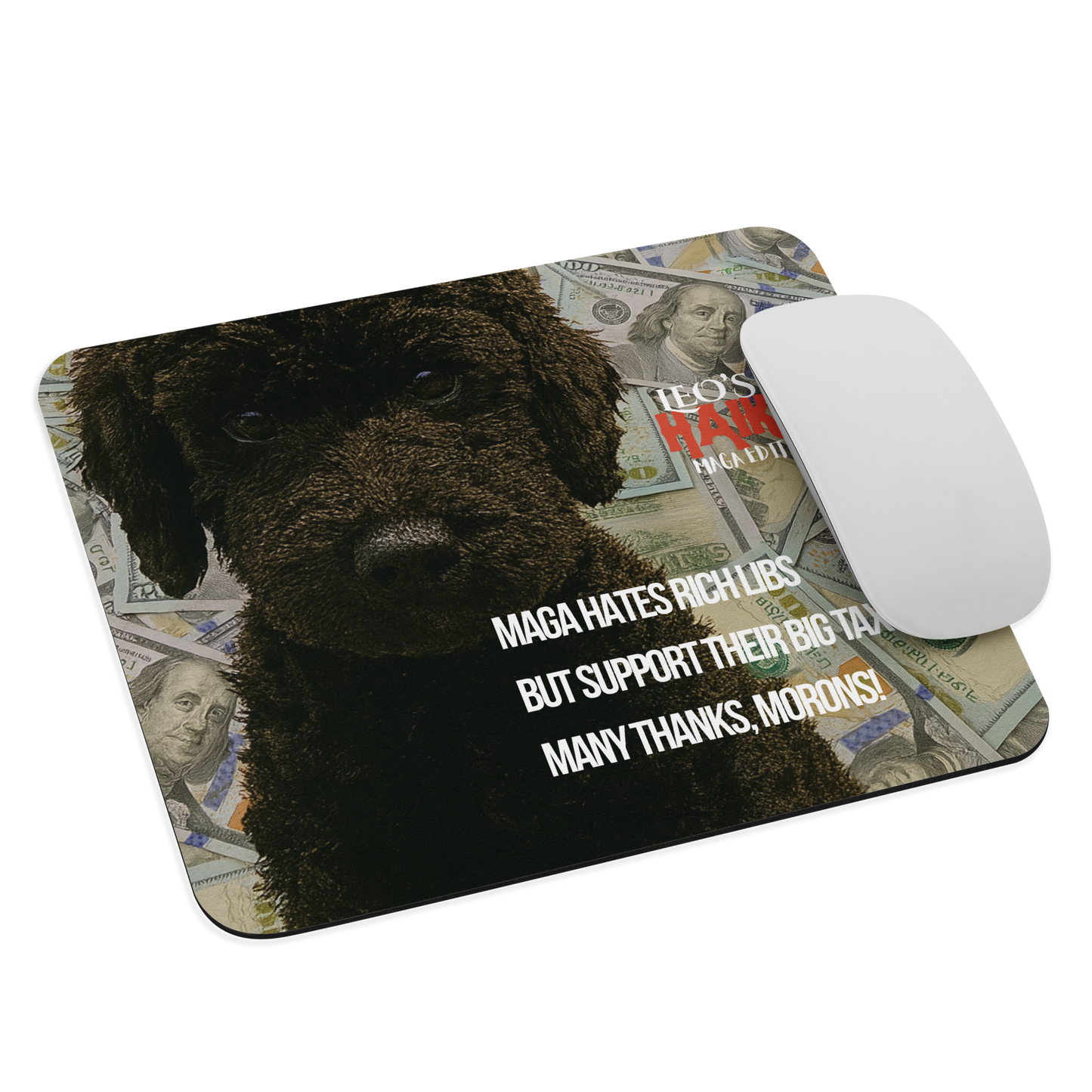 A standard-sized mouse pad printed with the large face of black dog with $100 bills behind him; political satire text and brand; a computer mouse sits on the right edge of the pad.
