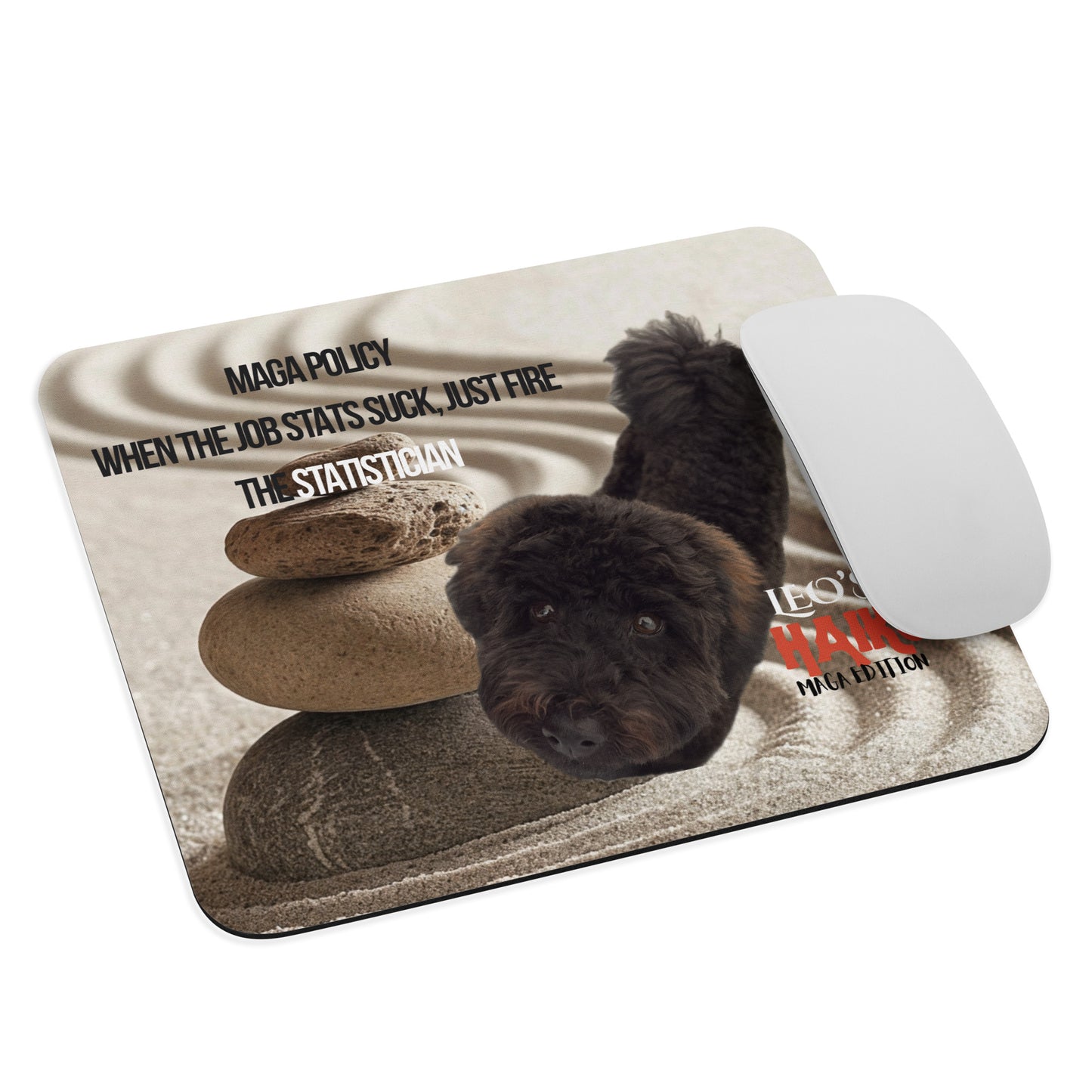 A standard-sized mouse pad printed with the image of a black dog standing in a Zen garden with sand and a stack of rocks, political satire text and branding. A computer mouse sits at the right edge of the pad.