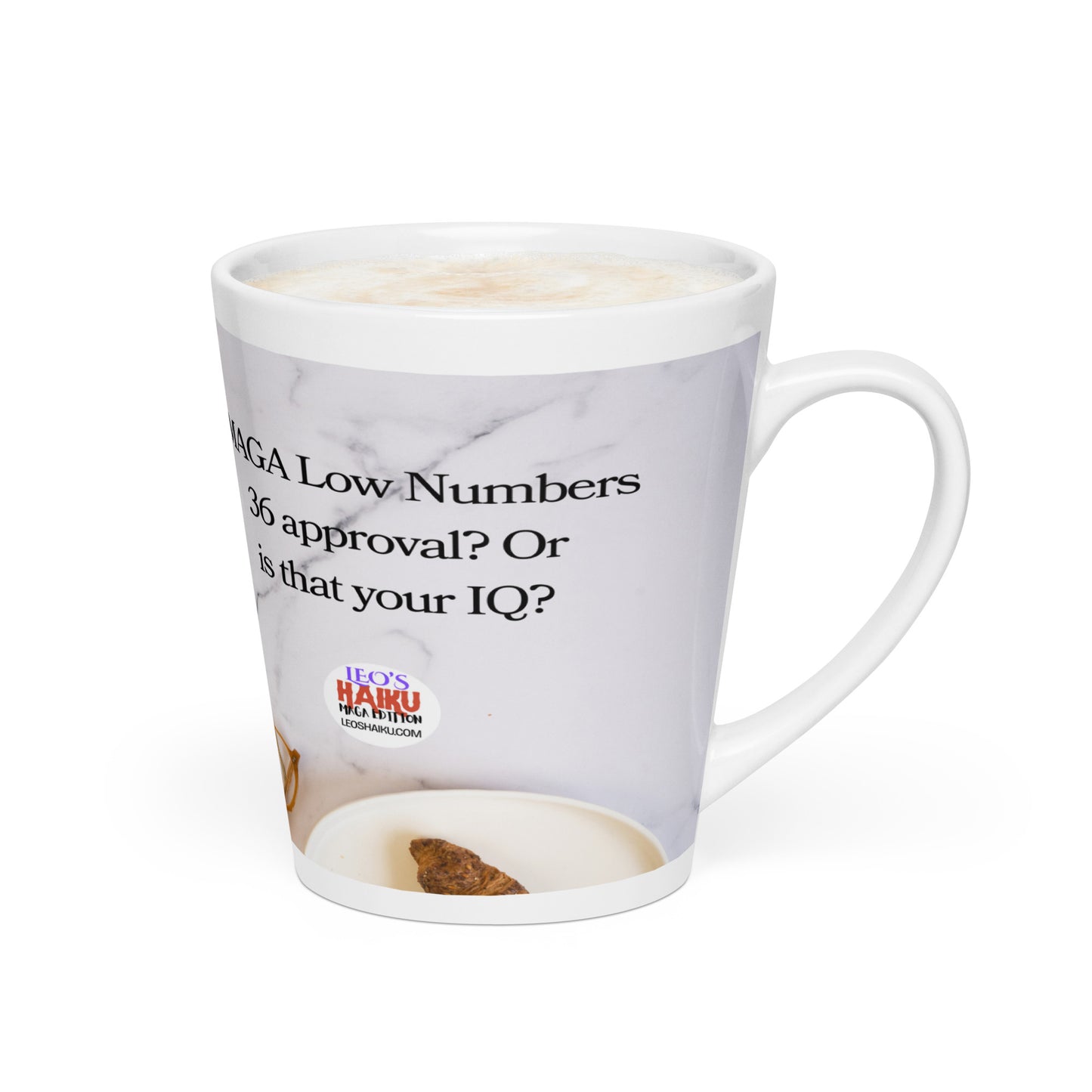 White glossy ceramic mug printed with image of a kitchen counter with a small plate and croissant.  Political, satirical, anti-MAGA haiku is partially visible. Text logo for leoshaiku.com is fully visible