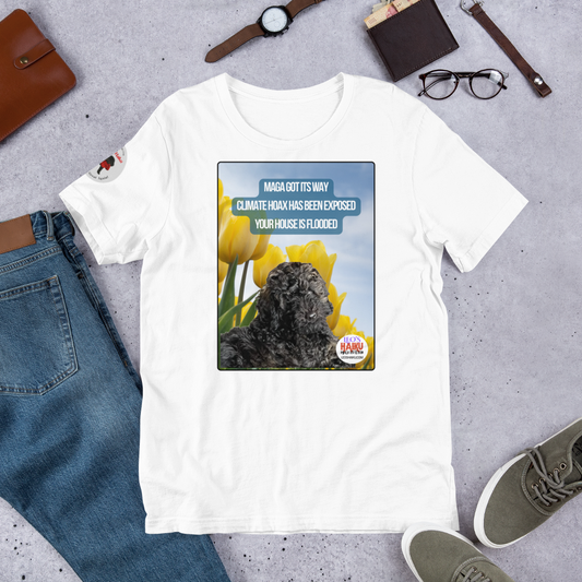 White t-shirt with a graphic design featuring text and an image of Leo the mini poodle.  Shirt is on a gray surface with jeans, shoes, and accessories.  Design on the shirt is Leo in a field of tulips under a blue sky.  A political, satirical, anti-MAGA haiku reads:
MAGA Got Its Way
Climate Hoax Has Been Exposed
Your House Is Flooded
The circular text logo for leoshaiku.com is bottom right.