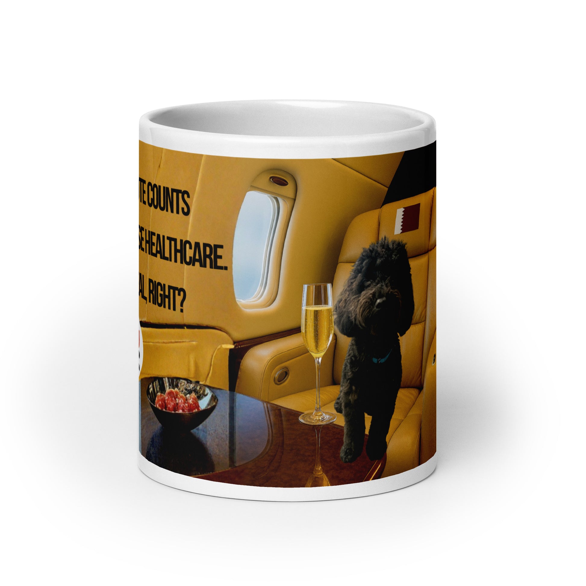 White glossy ceramic mug printed with image of a black dog in a leather plane window seat.  Tray table holds a bowl of red fruit and a glass of champagne.