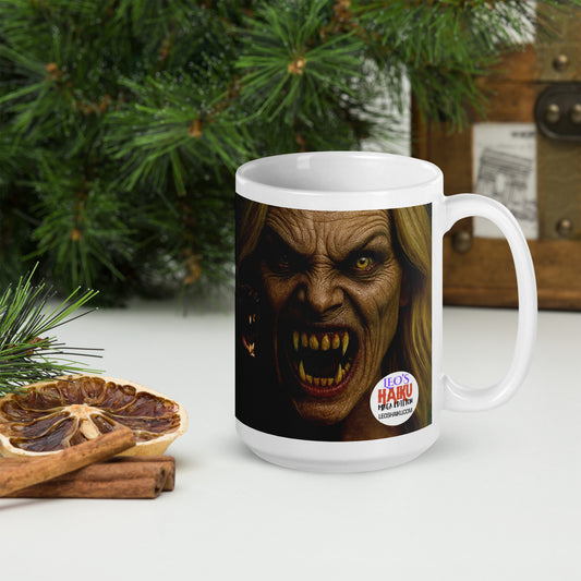 Glossy White Mug printed with the image of a monster face with fanged teeth.  Mug is on a white table with Christmas decorations.  Leoshaiku.com text logo is shown