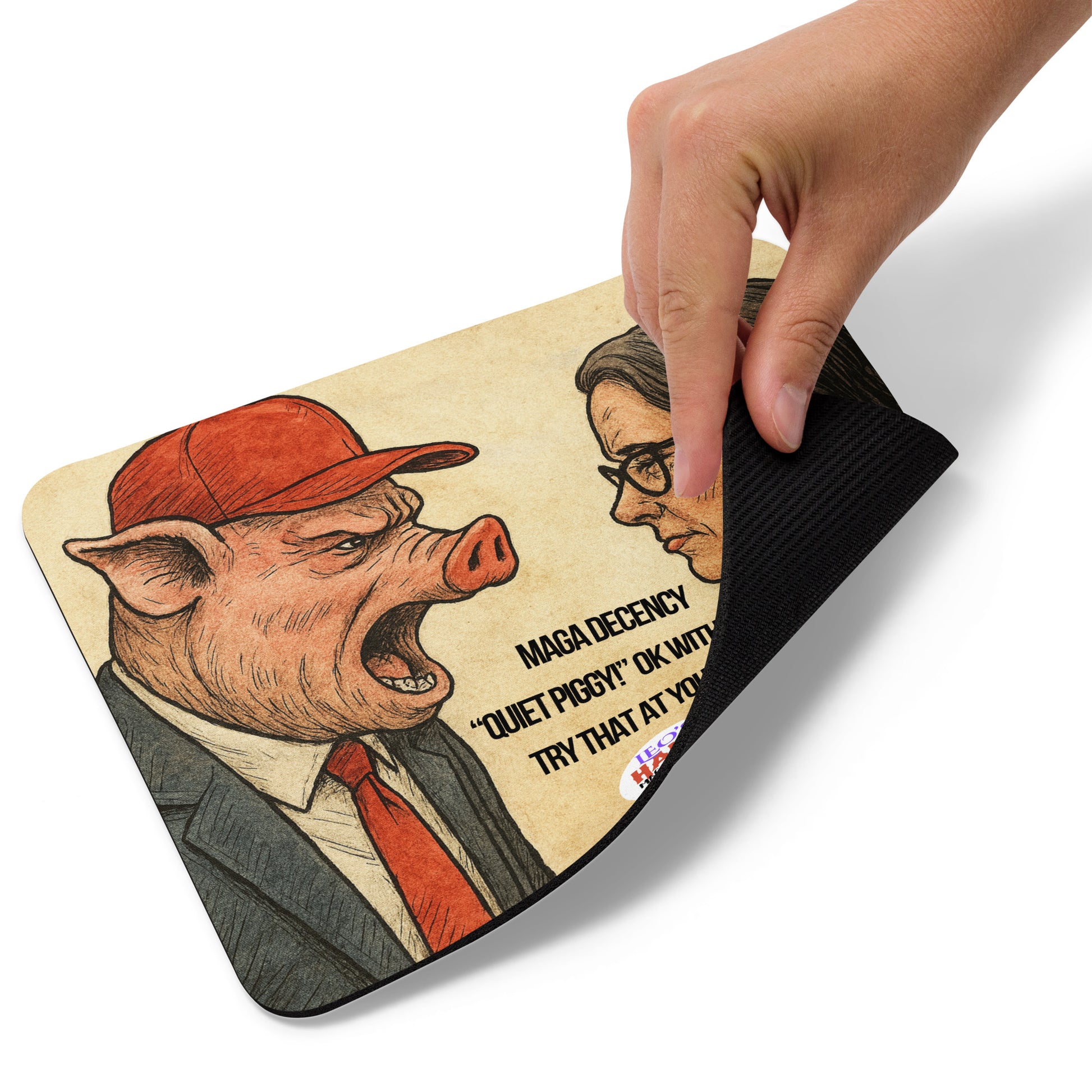 A hand lifts the lower right edge of a standard mouse pad printed with cartoon image of a pig-faced man in a suit, red tie, and red hat screaming at a woman in a business suit.  Political, satirical, anti-maga haiku is displayed as is the text logo for Leoshaiku.com and the image of a small dog.  This view shows the thickness of the pad.