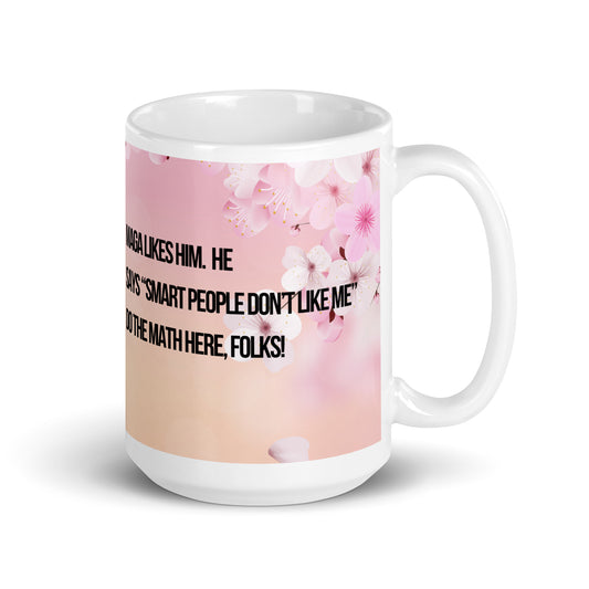 White ceramic mug printed with a pink and white flowered background.  Political, satirical, anti-MAGA haiku is partially visible.