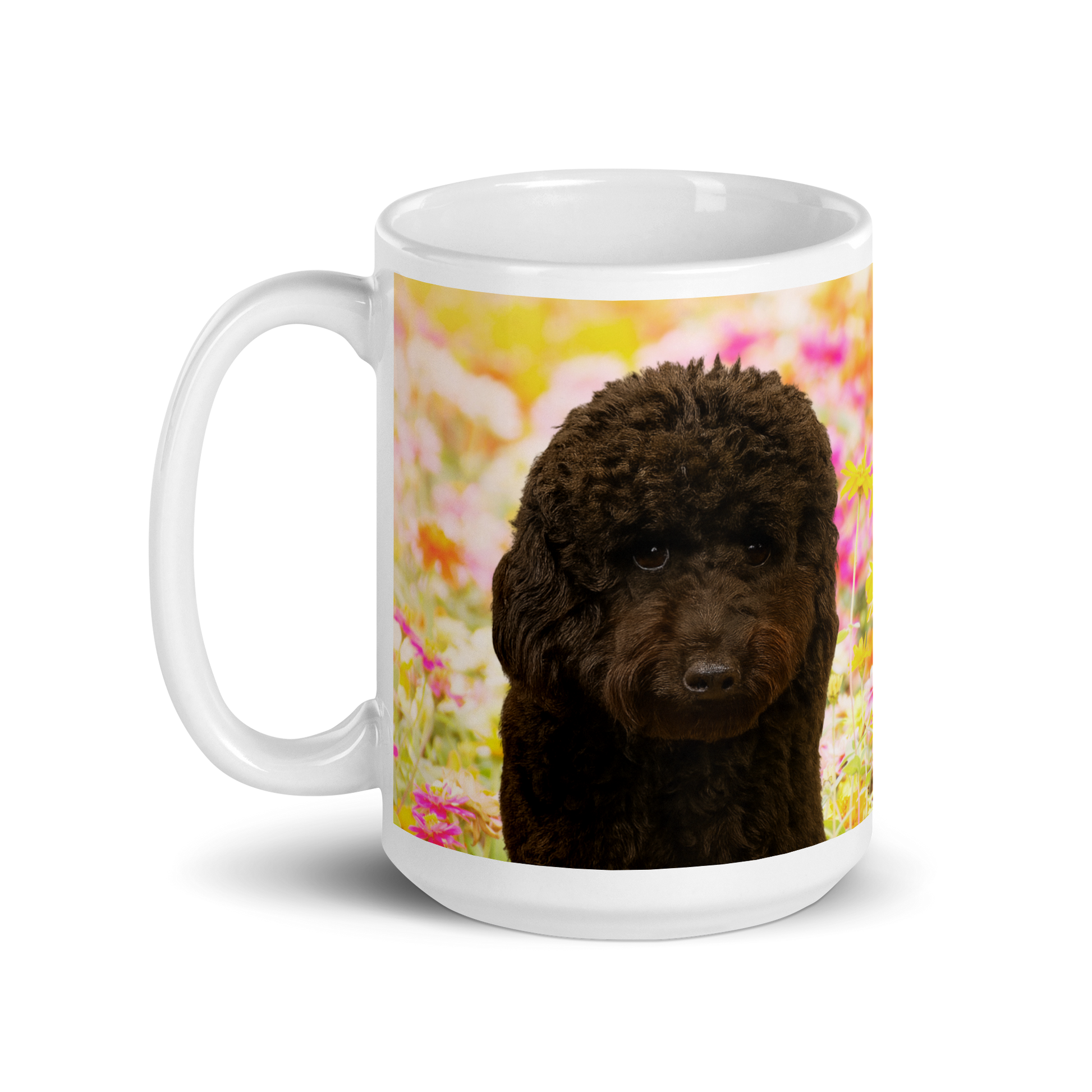 White ceramic mug printed with a yellow and pink flowered background. Image of Leo, the black ini poodle, is displayed.