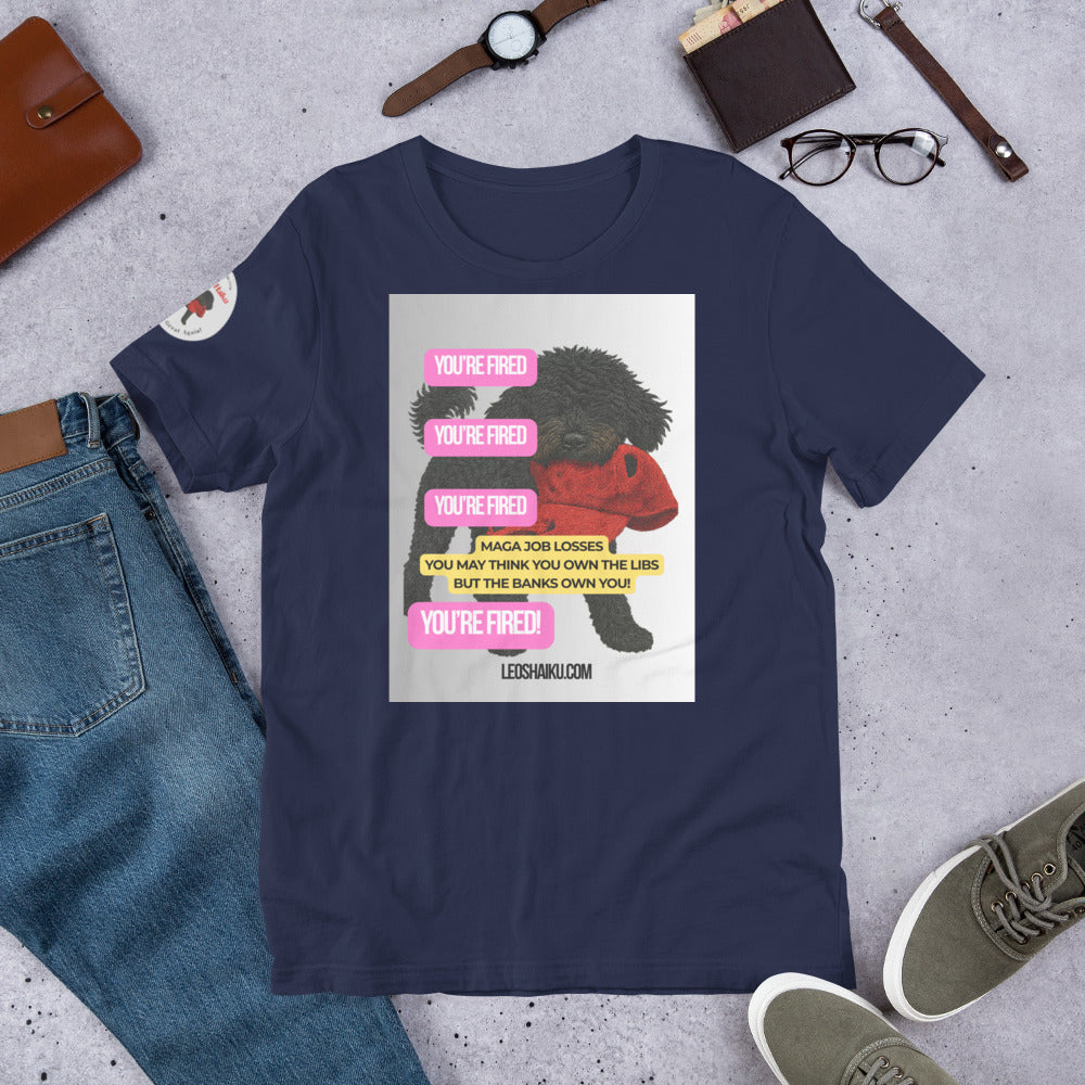 Navy blue t-shirt with printed image of Leo the black mini poodle with a chewed red cap in his mouth.  Shirt is surrounded by jeans, watch, glasses, and shoes.  YOU'RE Fired is displayed 4 times in pink.  A political , satirical, anti-MAGA haiku reads:
MAGA Job Losses
You May Think You 0wn the Libs
But the Banks Own You!
Bottom Center it reads "Leoshaiku.com" 