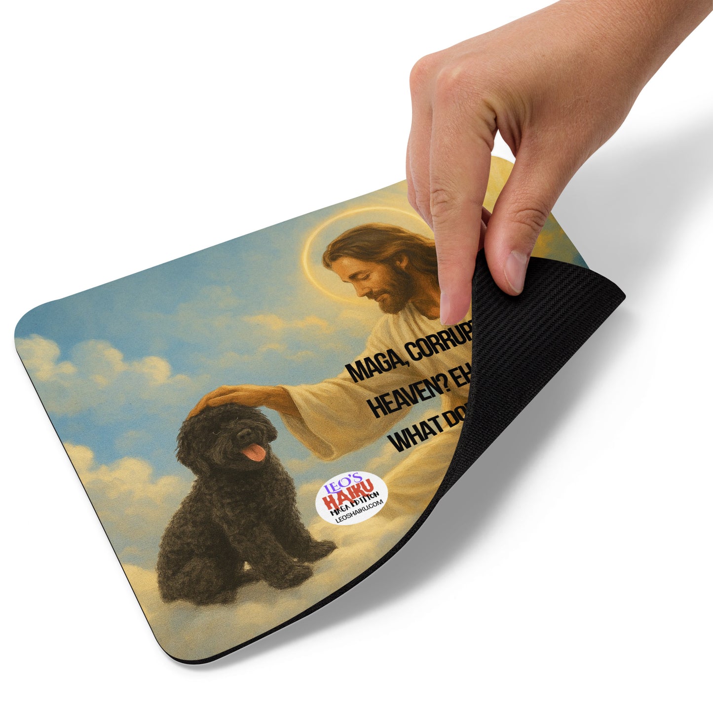 A hand lifts the lower right edge of a standard Mouse Pad printed with an image of a small black dog sitting on a cloud in heaven with Jesus, who is patting him on the head.  The text logo for leoshaiku.com is shown as is the political, satirical anti-MAGA haiku that reads:
MAGA, Corrupt King
Heaven? Eh, Not So Sure
What Does Jesus Think?