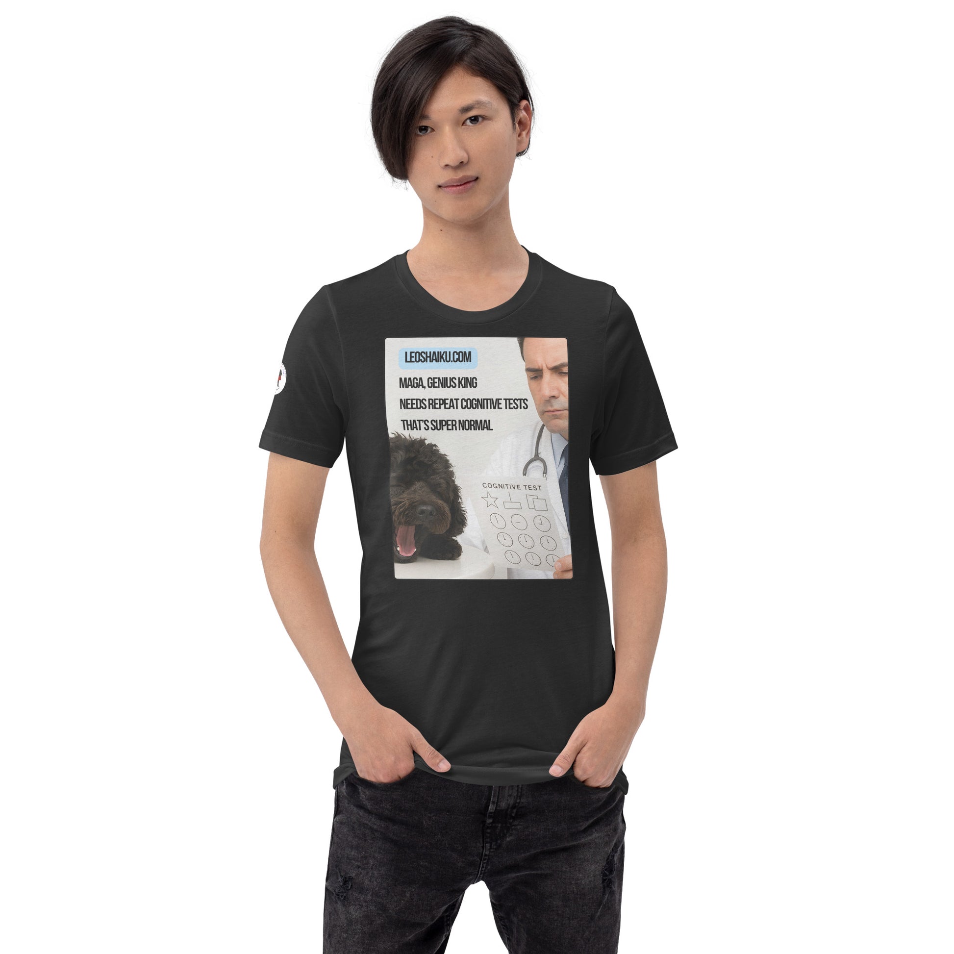 Young man, facing front in dark grey  t-shirt and black jeans.  Shirt is printed with the image of a small black dog asleep on an exam table in front of a doctor holding a cognitive test.  A political, satirical, anti-MAGA Haiku reads:
MAGA, Genius King
Needs Repeat Cognitive Tests
That's Super Normal.
Center above it says leoshaiku.com in black letters on a blue background.