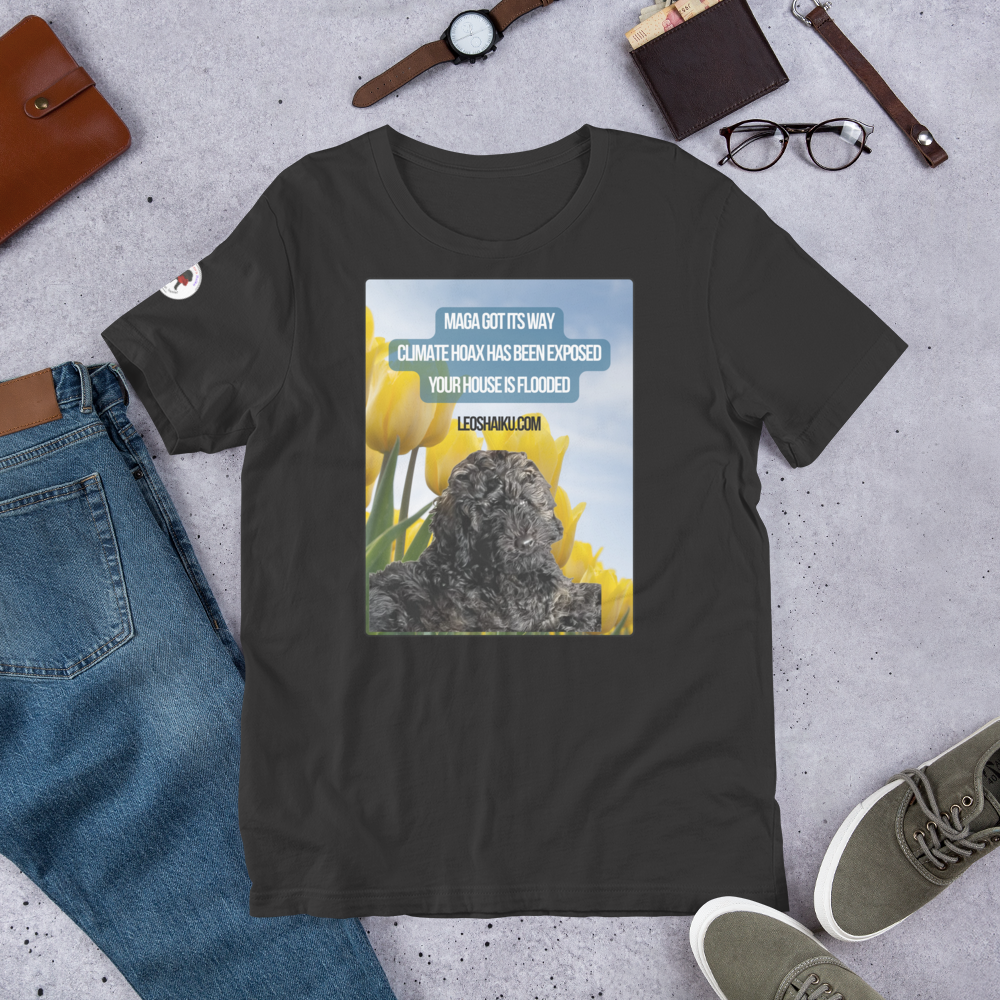 Dark Grey t-shirt surrounding by jeans, shoes, glasses, watch.  T-shirt is printed with the image of a black dog in a field of yellow tulips.  A political, satirical, anti-MAGA haiku reads:
MAGA Got Its Way
Climate Hoas Has Been Exposed
Your House is Flooded!
Centered below it reads Leoshaiku.com