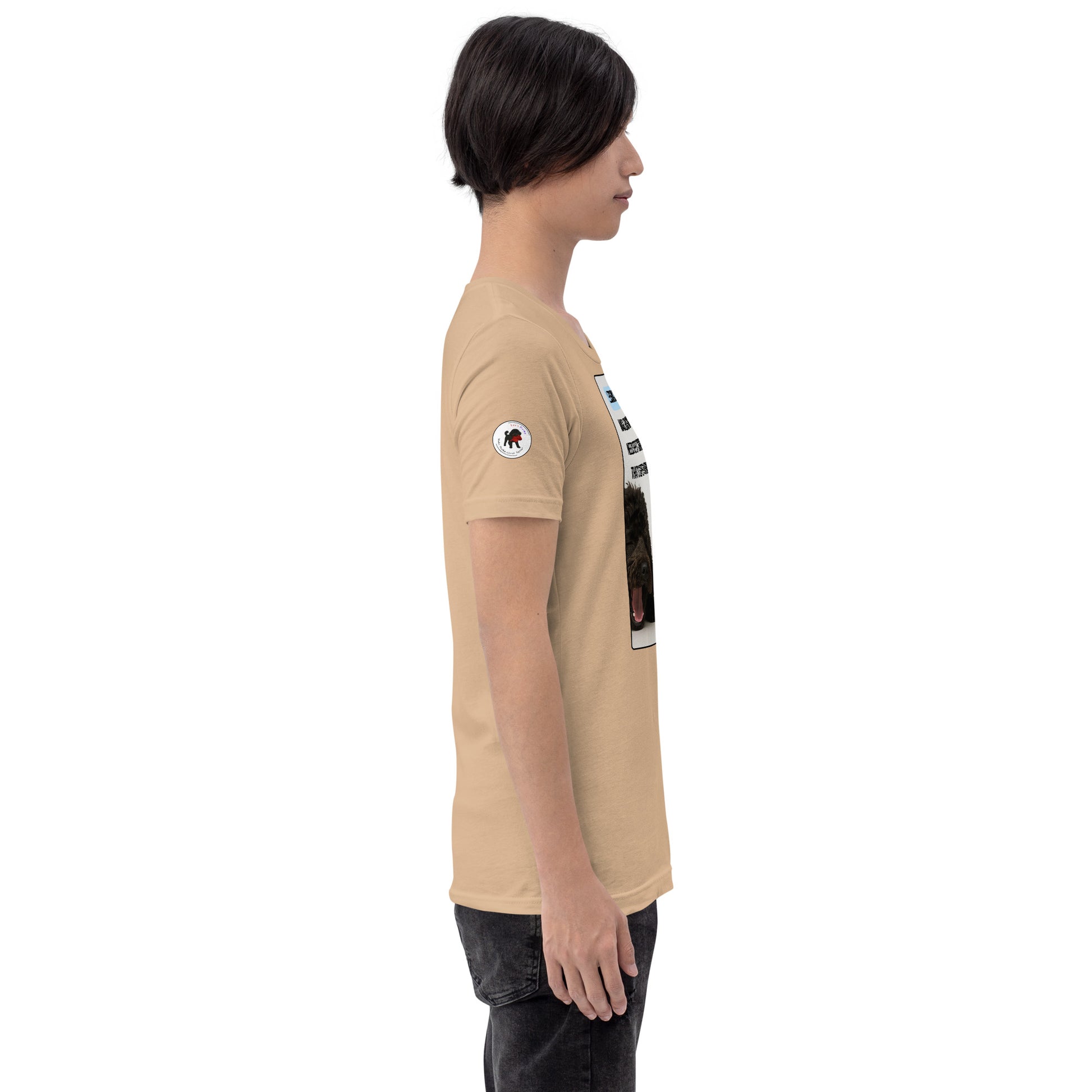 Young man in tan t-shirt facing right.  White circular logo on sleeve.