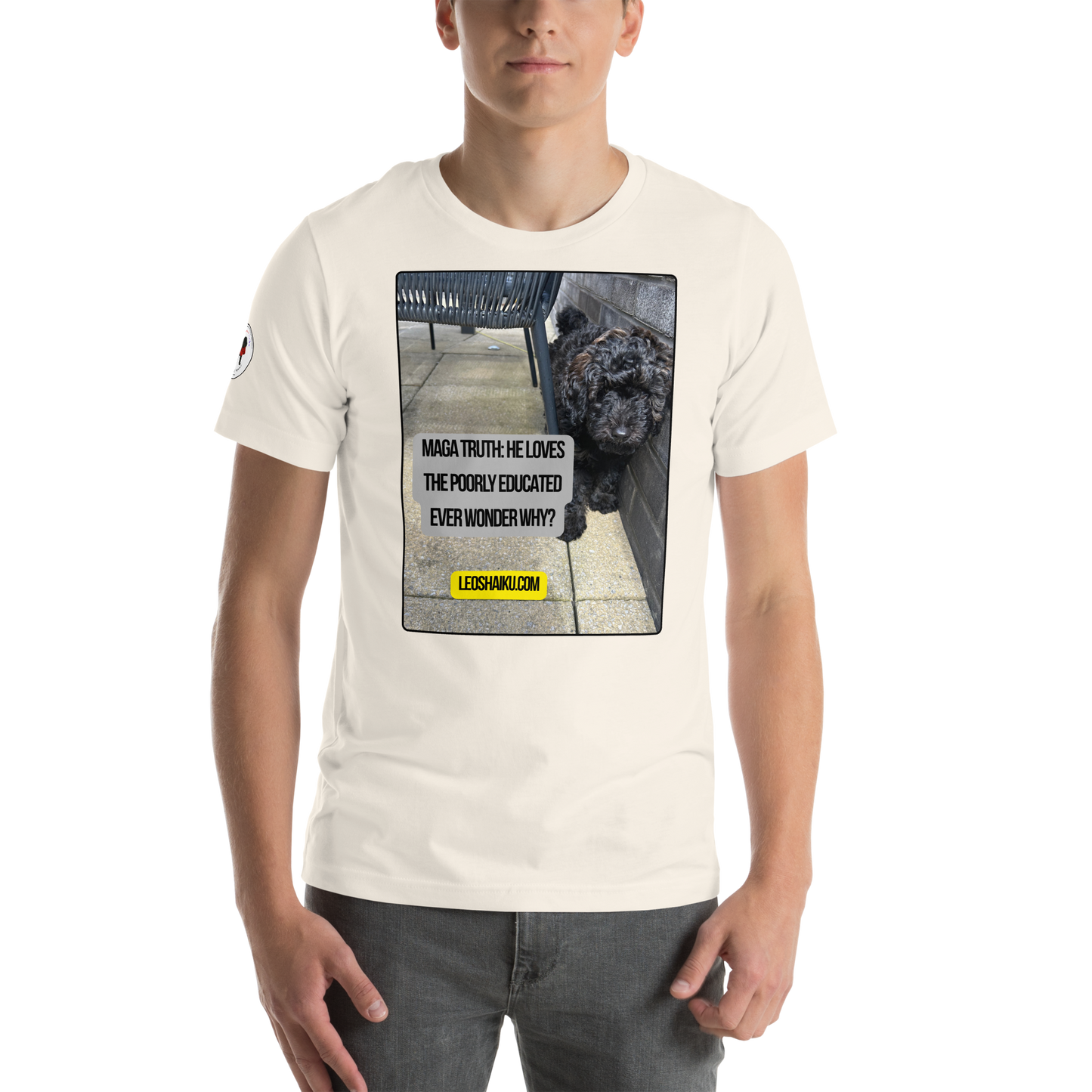 Young man in a white t-shirt facing front. Shirt is printed with the image of a dog huddled against an outside patio wall.  A political, satirical, anti-maga haiku reads:
MAGA Truth:  He Loves
The Poorly Educated
Ever Wonder Why?
centered below that in black letters on a yellow field, it reads LEOSHAIKU.COM
